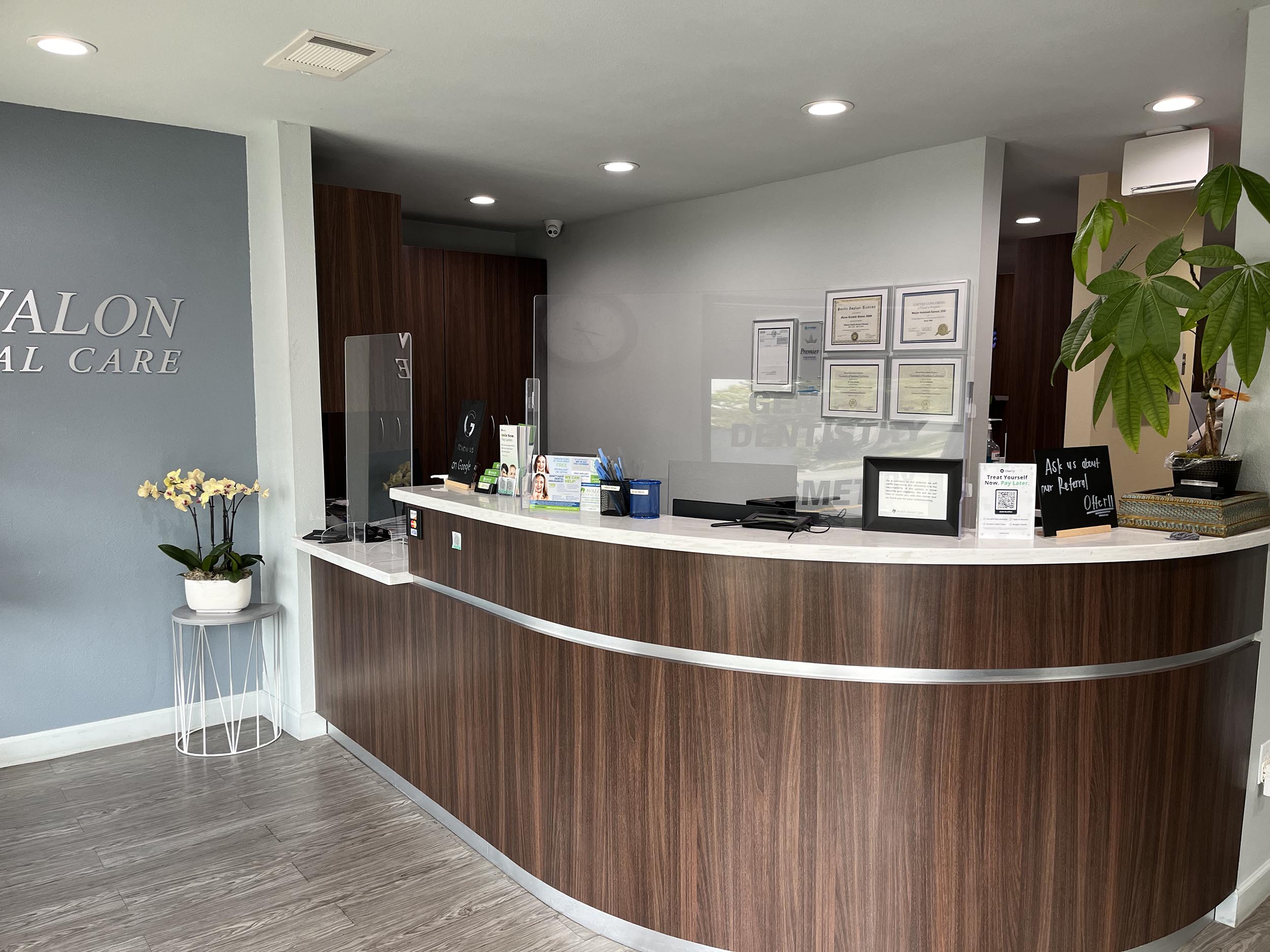 Front desk reception area at Avalon Dental Care with certification plaques and welcoming decor