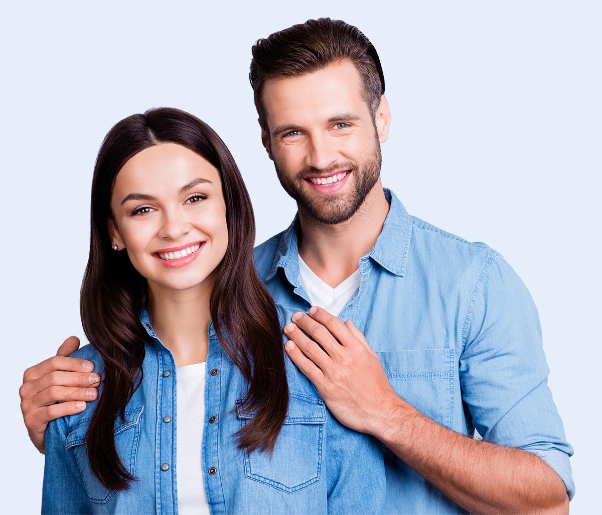 Photo of happy married couple, husband holding his hands on his wife's shoulders against gray background